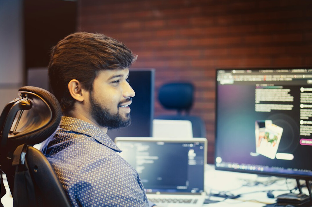 successful programmer smiling at desk